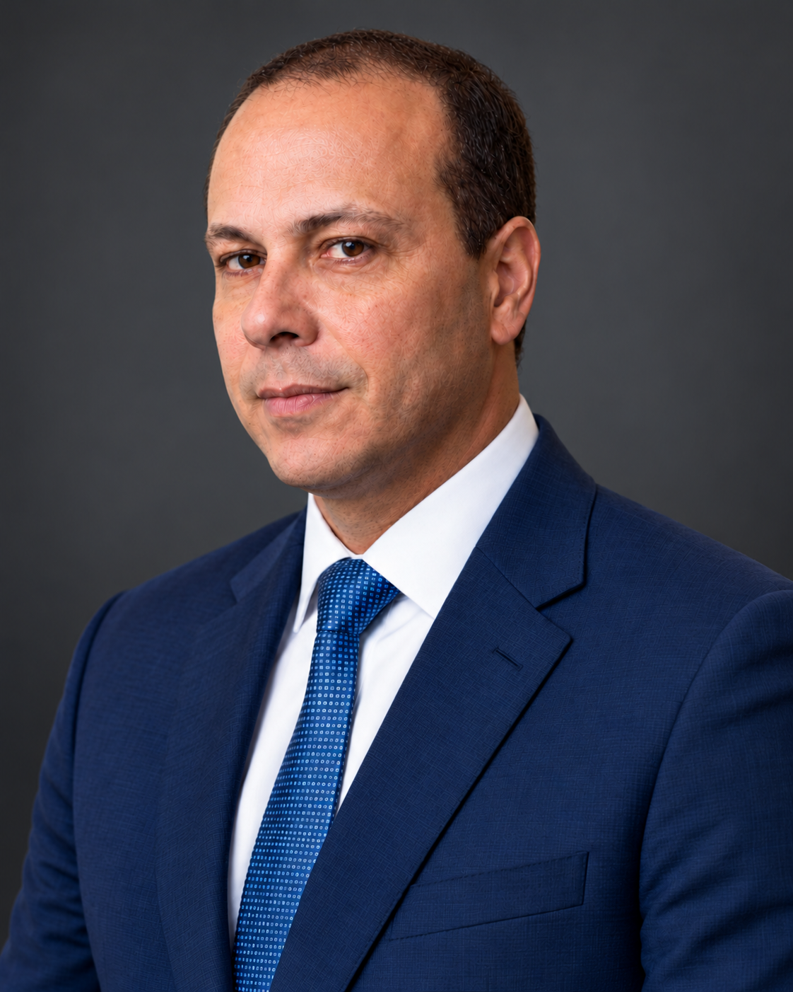 Dr. Adriano França Chaves, de terno azul, olhando para a câmera